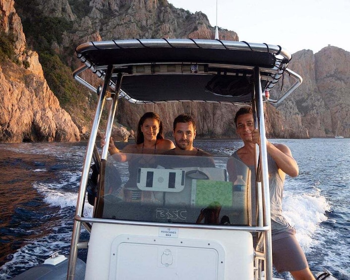 Un bateau avec trois personnes à bord, dans une zone côtière rocheuse. 5