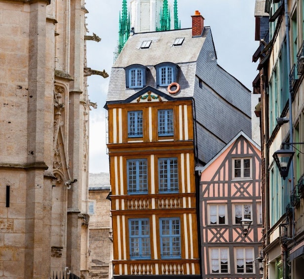 A narrow street lined with historic half-timbered buildings and a Gothic cathedral. 3