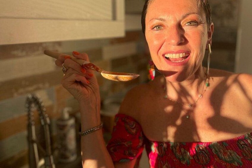 A person holding a spoon with food, wearing a floral dress, and a bracelet. 4