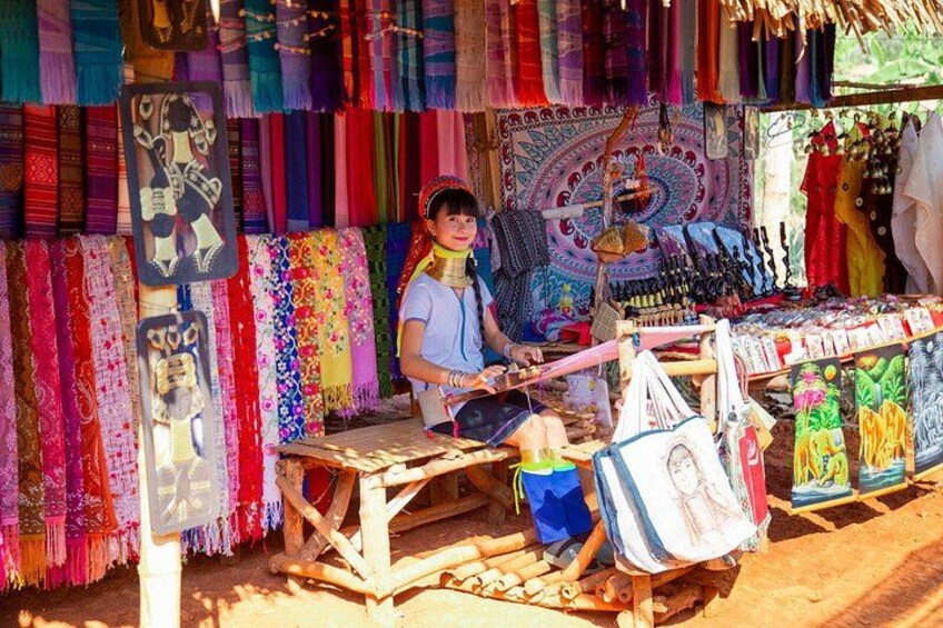 A market stall with colorful textiles and a person sitting behind the counter. 2