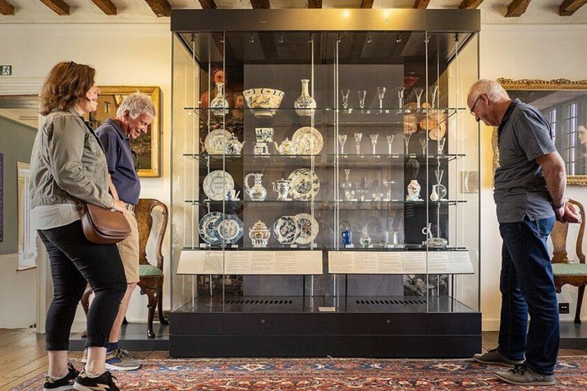 A museum exhibit with glass display cases containing ceramic items. 2