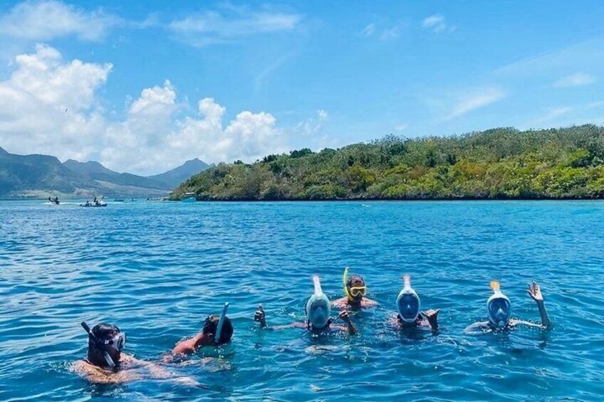 People swimming in a clear blue lake with mountains in the background. 4