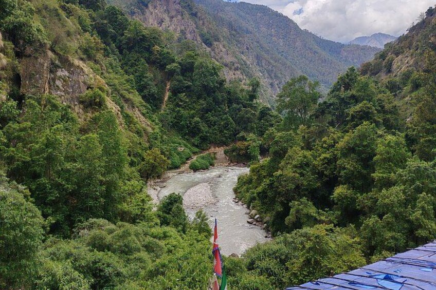 A river winding through a lush valley with dense greenery and rocky cliffs. 5