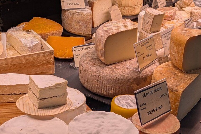 Various types of cheese displayed in a market. 5