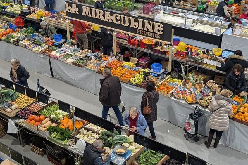 A bustling outdoor market with various stalls selling fruits, vegetables, and other goods. 4