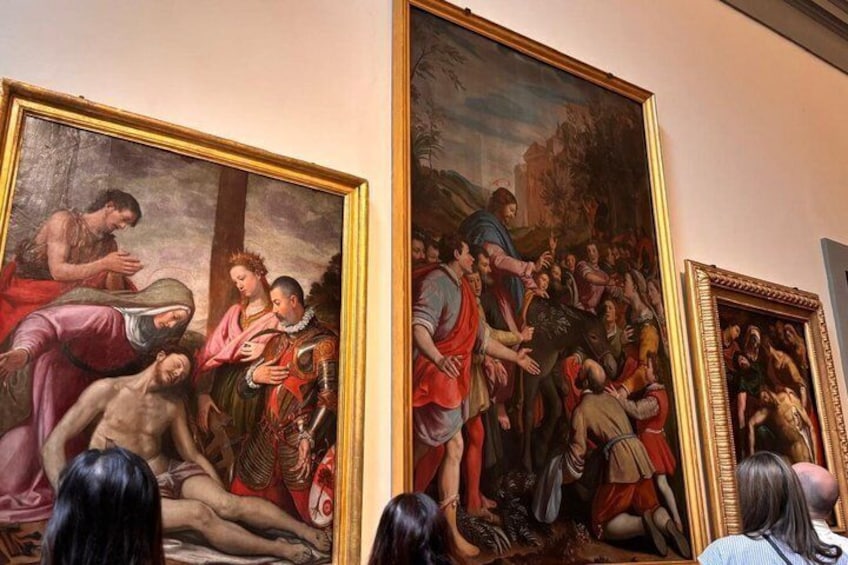 A classical painting with figures in various poses, framed and displayed on a wall. 4