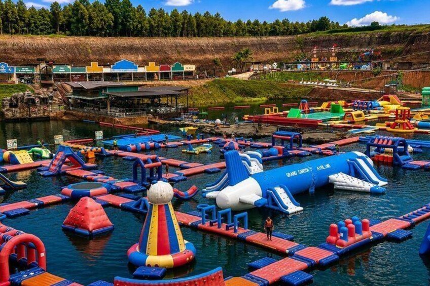 A water park with inflatable play structures and a blue water slide. 2