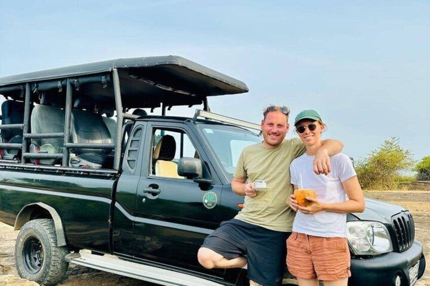 A black pickup truck with a roof rack and a person holding a drink. 3