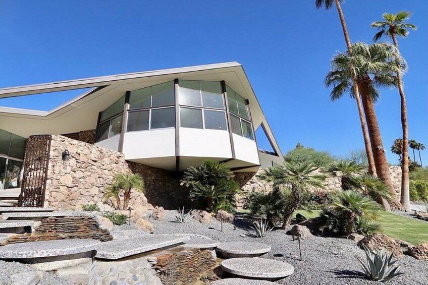 A modern house with a sloped roof, large windows, and a stone facade. 5