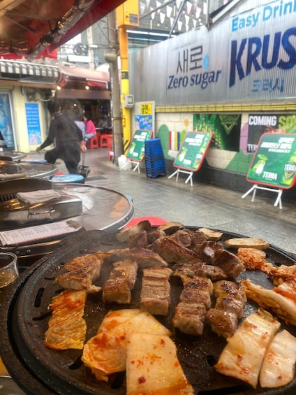 Katukojuja, joissa myydään grillattua lihaa, ja kyltti, jossa mainostetaan sokerittomia juomia. 4