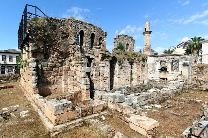 Ancient ruins with stone walls and arches, a watchtower, and a mosque. 1