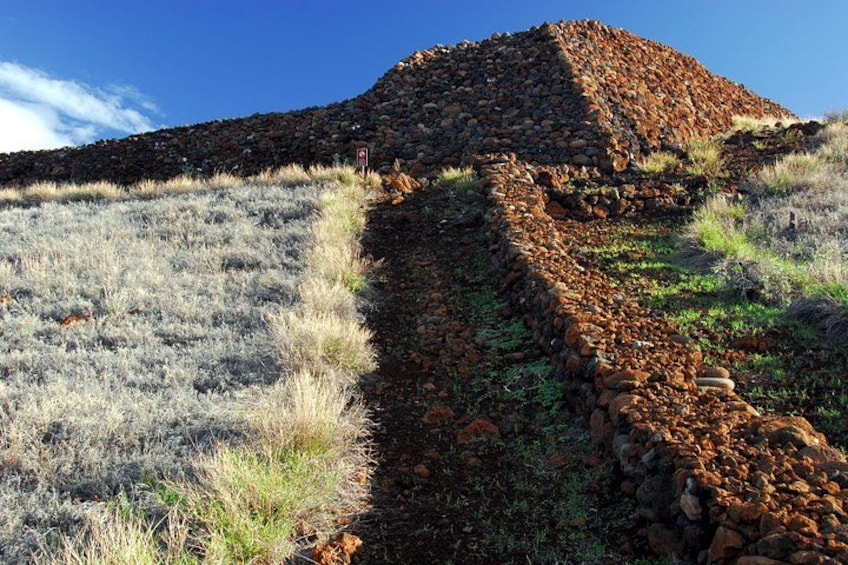 Una edificación de piedra con un cielo despejado al fondo. 5