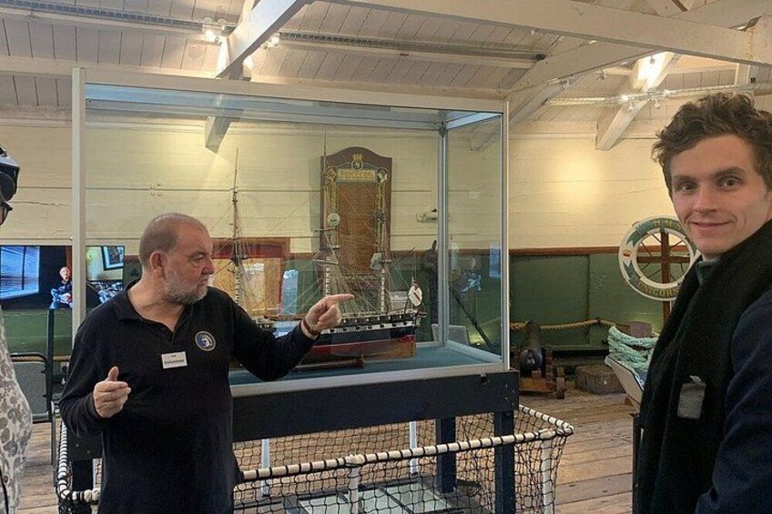 A museum exhibit with a model ship and a glass display case. 2