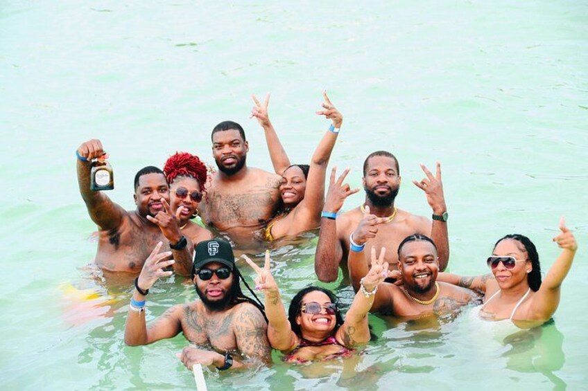A group of people in a body of water, some making hand gestures. 2