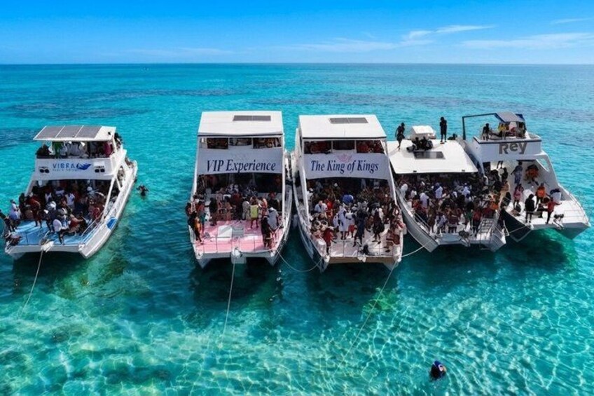 Three boats named 'VIP Experience,' 'The King of Kings,' and 'Rey' anchored in clear turquoise water. 1