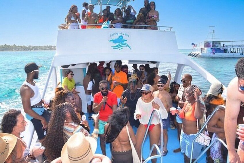 A boat with people on deck, water in the background, and a clear sky. 5