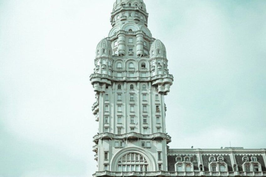 A tall, ornate building with intricate architectural details and a large arched entrance. 3