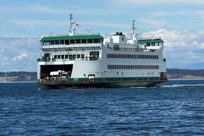 A ferry with multiple decks, a green and white color scheme, and an American flag on the top. 3