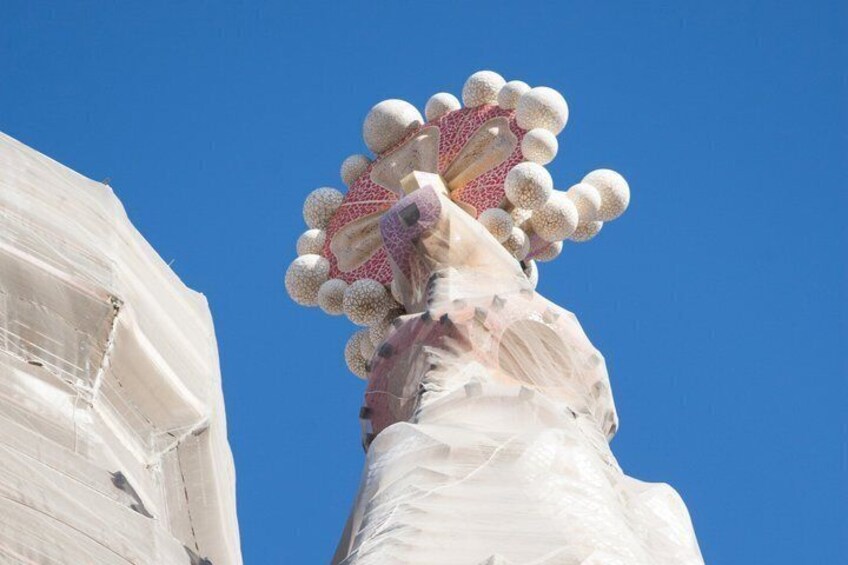 A large white statue with a pink and white patterned top, set against a clear blue sky. 2