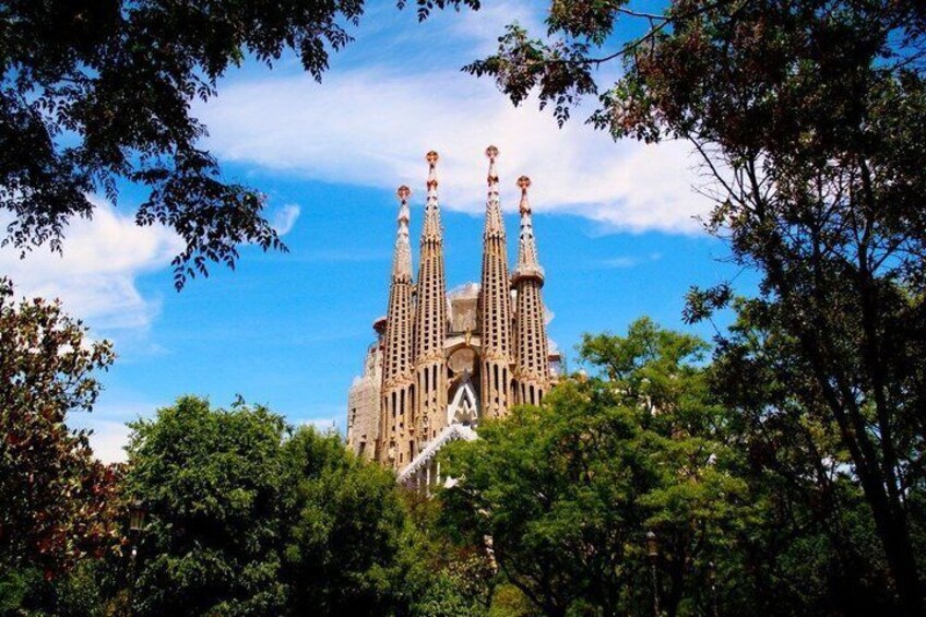 A large, ornate building with multiple spires, surrounded by lush green trees. 4