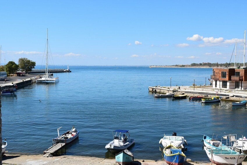 A marina with boats docked, a pier, and a building with a wooden facade. 1