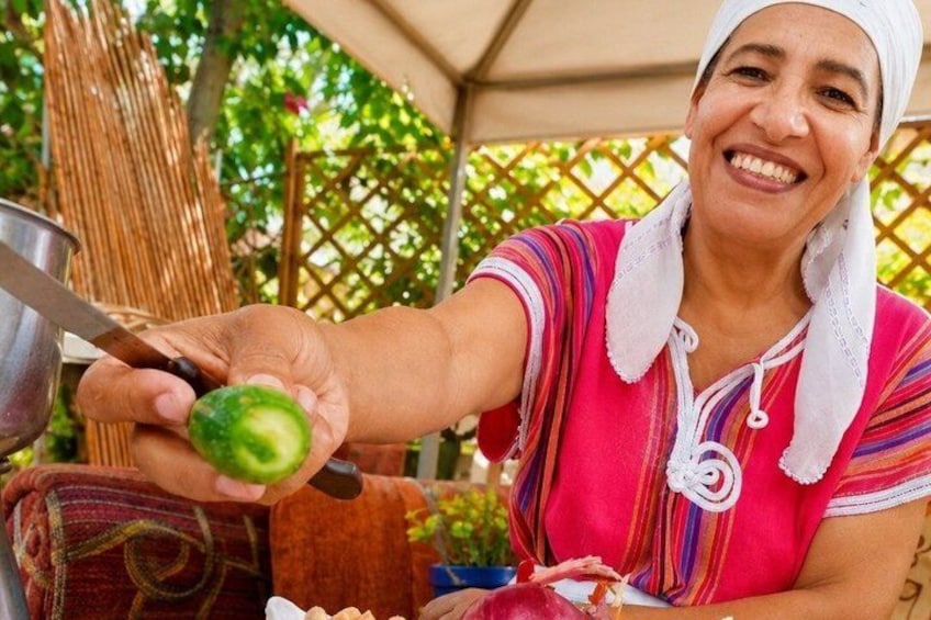 A person holding a green fruit, possibly a guava, with a metal bowl and a knife. 5