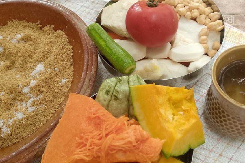 A variety of vegetables and a bowl of brown sugar. 2