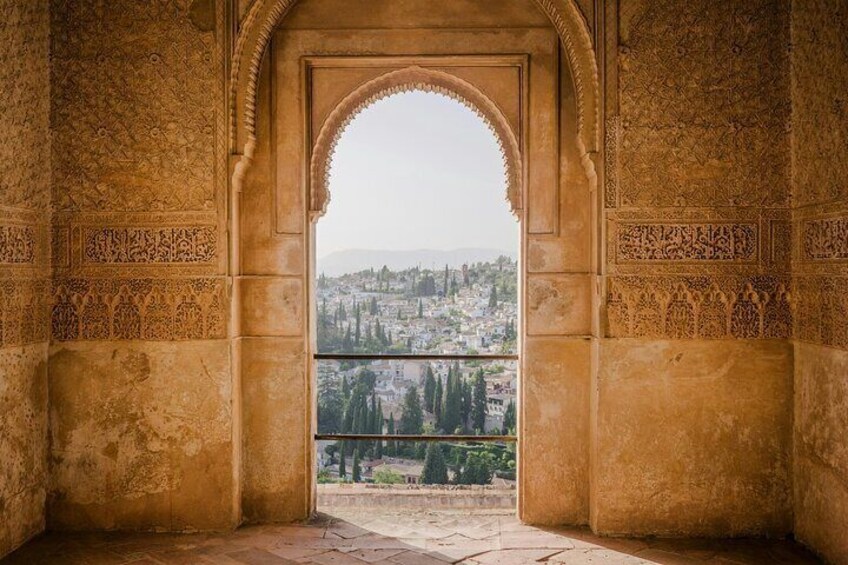An arched doorway with intricate carvings, leading to a view of a cityscape. 3