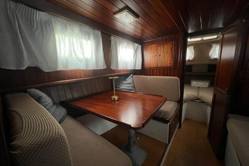 A cozy interior with a wooden table, cushioned seating, and curtains. 4