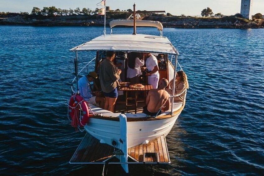 A boat with people on board, docked near a lighthouse. 4