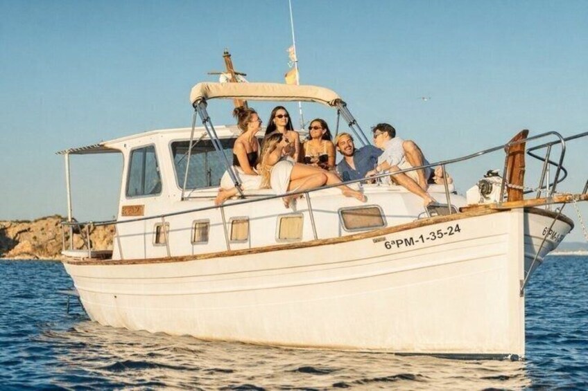 A white boat with people on board, a rocky shoreline in the background, and calm water. 1