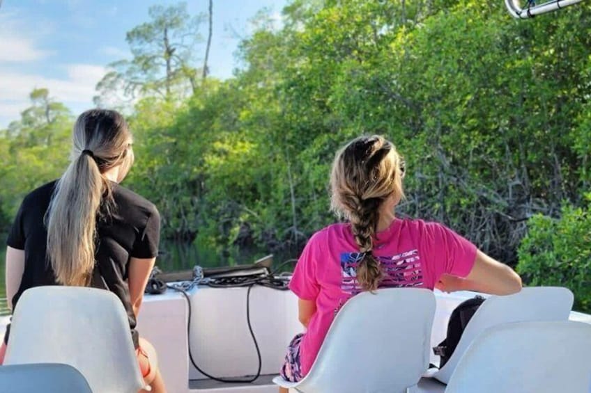 Two people on a boat with a forested background. 3