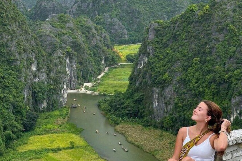A river with boats, surrounded by steep cliffs and lush greenery. 5