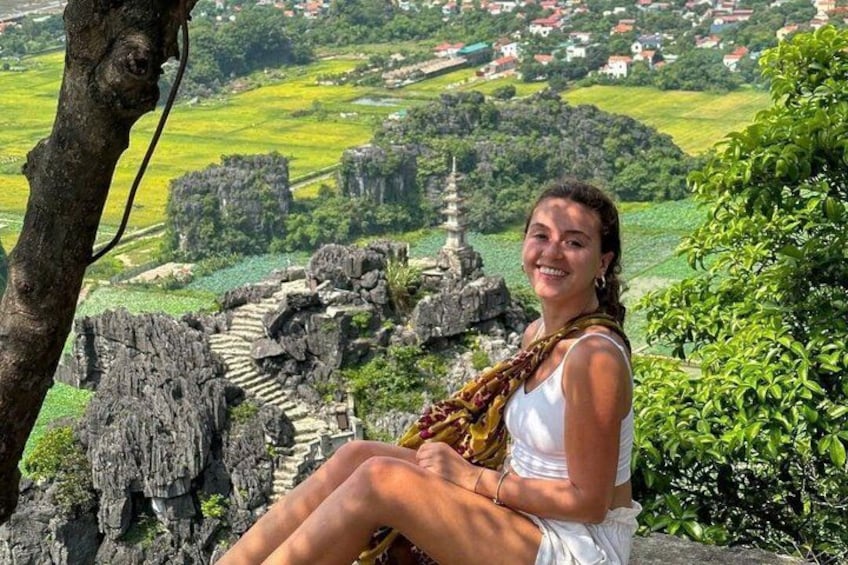 A person sitting on a rock with a temple in the background. 2