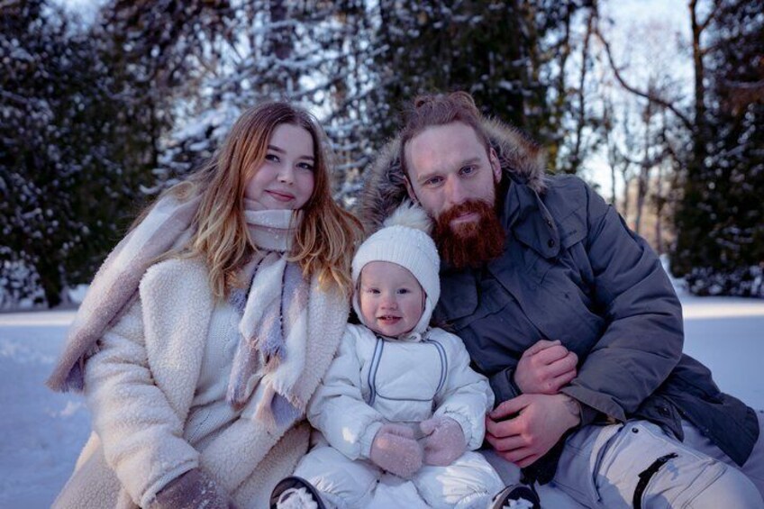 A family of three in a snowy outdoor setting. 4