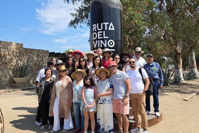 A group of people posing in front of a sign that reads 'Ruta del Vino.' 3
