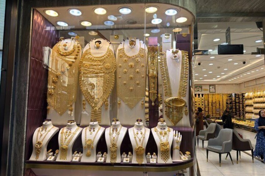 A jewelry store with gold necklaces and bracelets on display. 3