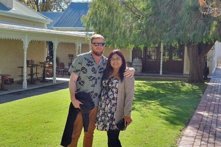 A man and a woman standing in a courtyard with a building in the background. 2