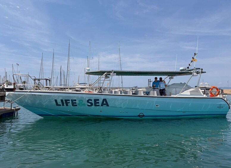 A boat named 'LIFE SEA' docked at a marina with other boats in the background. 2