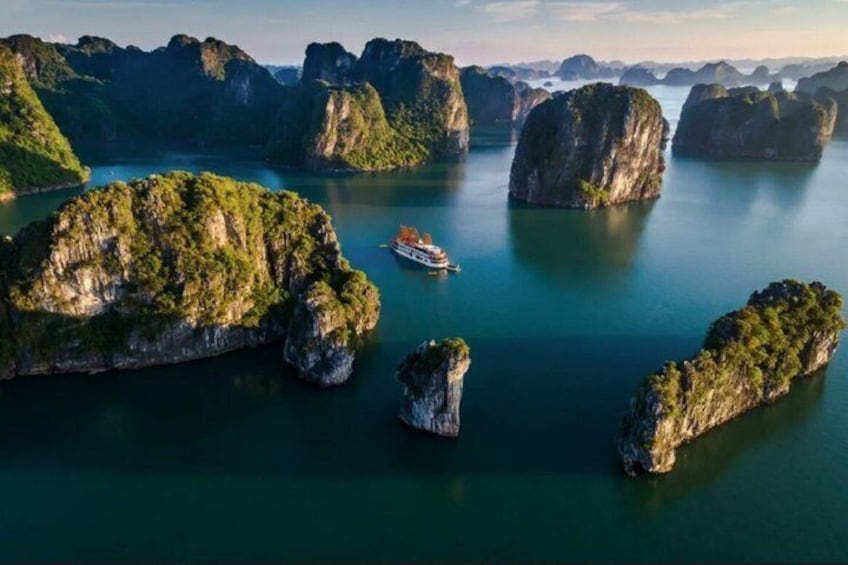A boat on a calm river surrounded by limestone karsts. 1