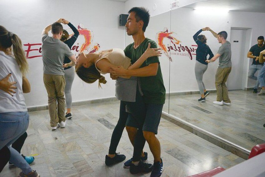 A dance class in a studio with mirrors on the walls. 4