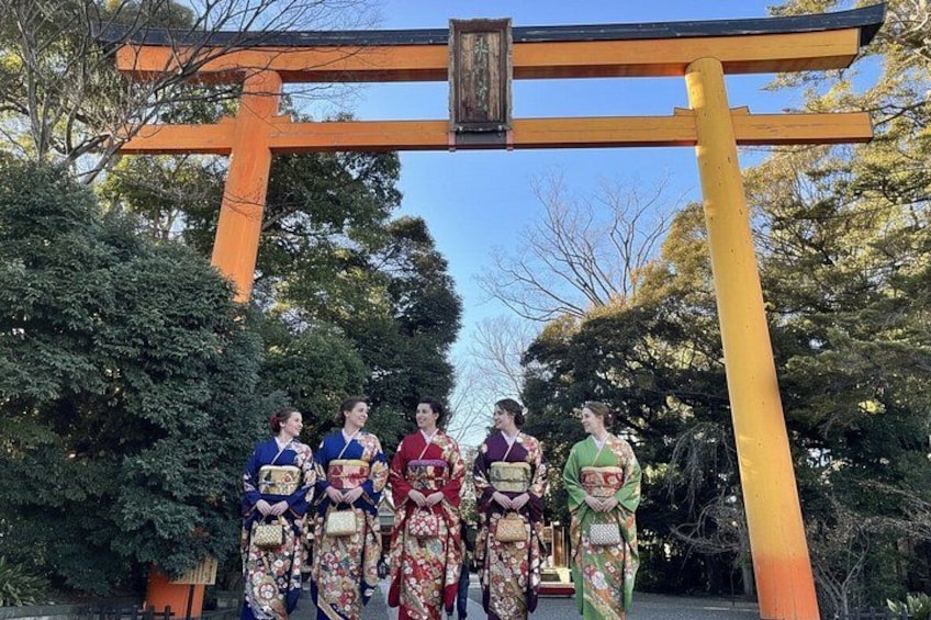 En grupp människor klädda i traditionella japanska dräkter som står under en torii-port. 3