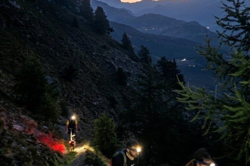 A mountain trail with hikers and a cyclist. 4