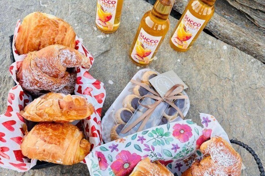 Pastries in paper bags, a floral gift box, and bottles of Cocco Piel. 5