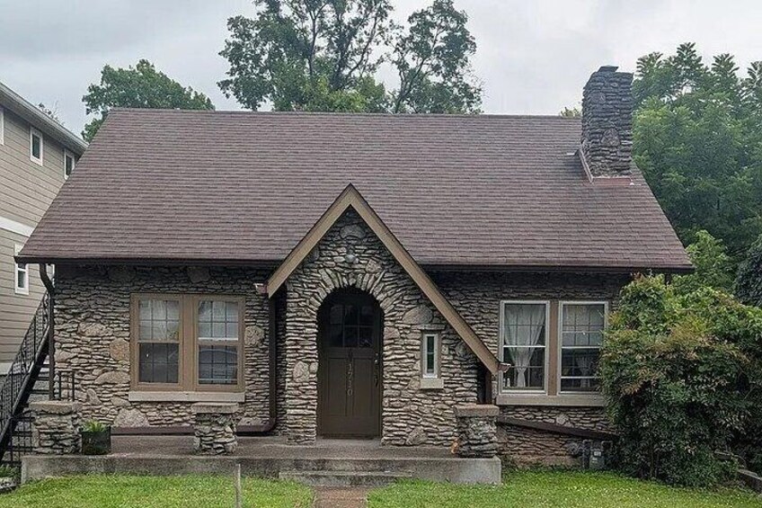 A stone house with a gabled roof and a chimney. 4