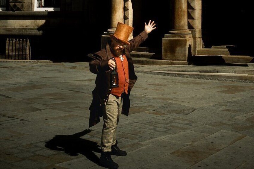 A person in historical costume standing on a stone pavement with a building in the background. 5