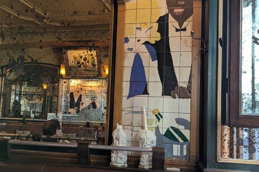 A mosaic wall with a man and woman, a wooden ceiling, and a window. 5