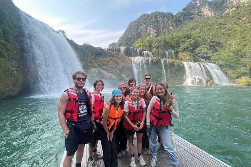 A group of people on a boat near a waterfall. 4