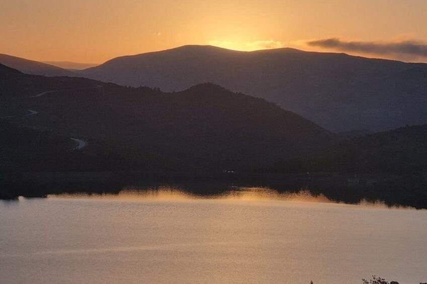 A mountain landscape with a lake reflecting the sunset. 4