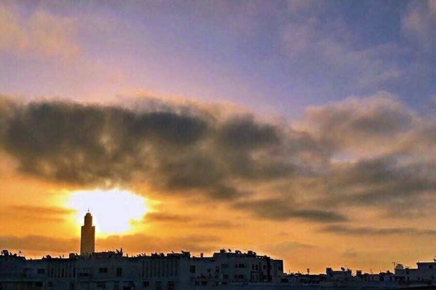 A sunset over a city skyline with a prominent tower silhouetted against the sky. 2
